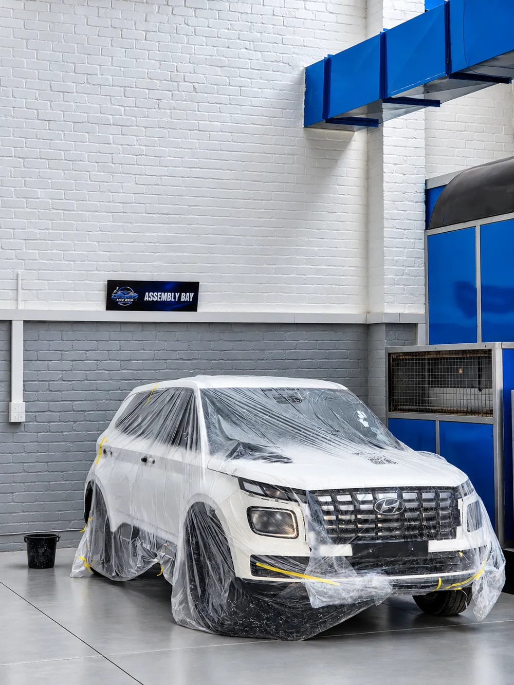 White Hyundai protected and prepared in the assembly bay